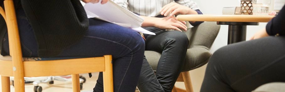En grupp människor som sitter runt ett träbord.