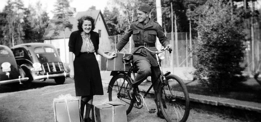 Ett gammalt foto av en man och en kvinna på en cykel.