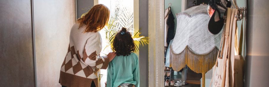 Kvinna visar ett barn något utanför fönstret