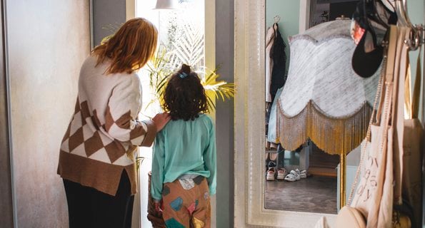 Kvinna visar ett barn något utanför fönstret