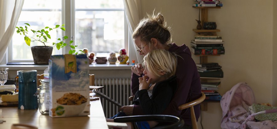 Surfar på läsplatta vid matbordet