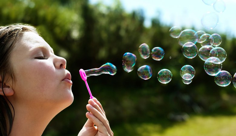Girl blowing bubbles outdoors