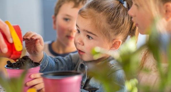 En grupp barn som leker med leksaker vid ett bord.