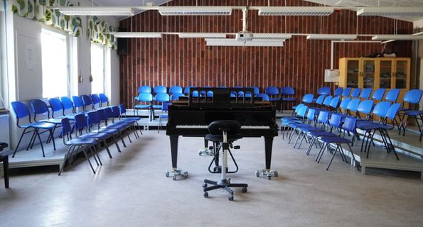 Ett rum fyllt med blå stolar och ett piano.