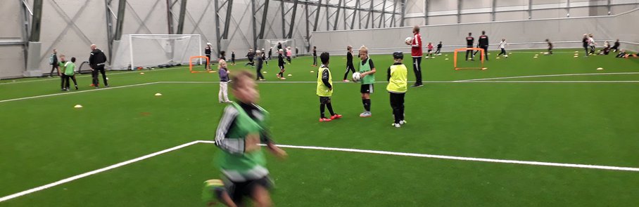 En grupp barn som spelar en fotbollsmatch inomhus.