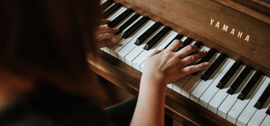 En flickas händer och ett piano.