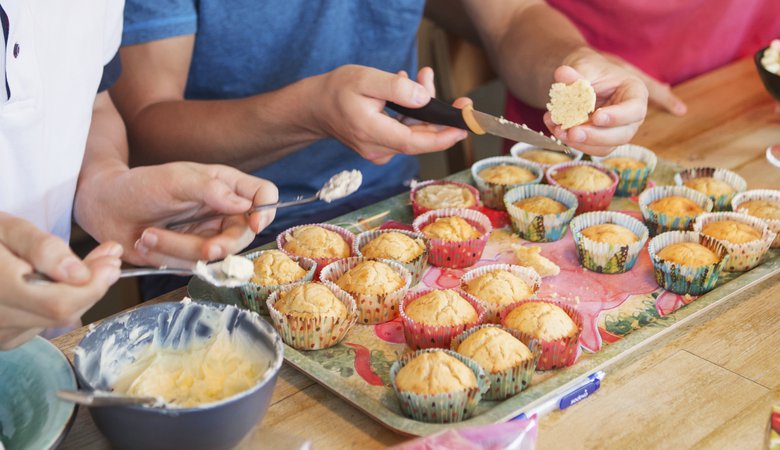 Tre killar bakar cupcakes vid ett k&ouml;ksbord