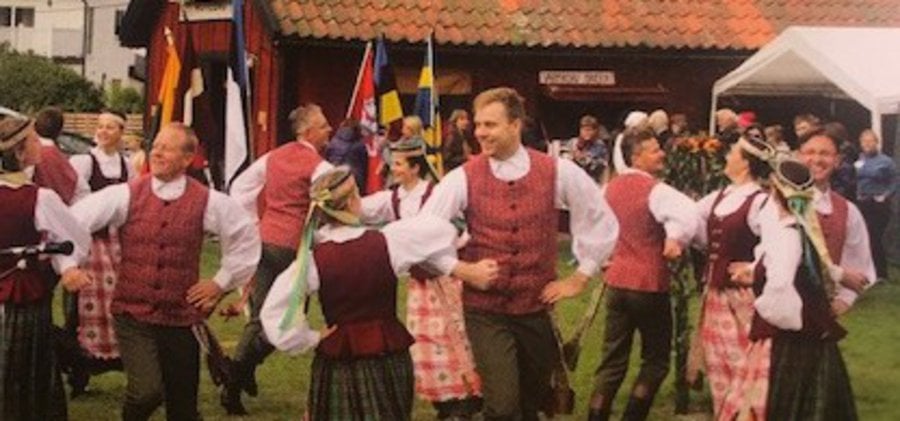 Dansande par i folkdräkter