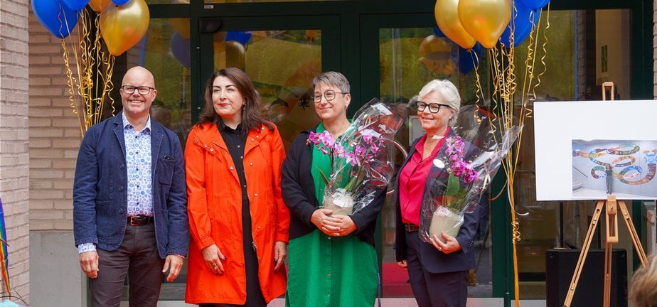 Fyra personer som står på en röd matta