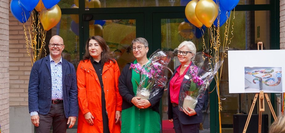 Fyra personer som står på en röd matta