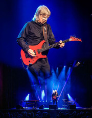 Janne Schaffer spelar gitarr på scen med spotlights och rök.