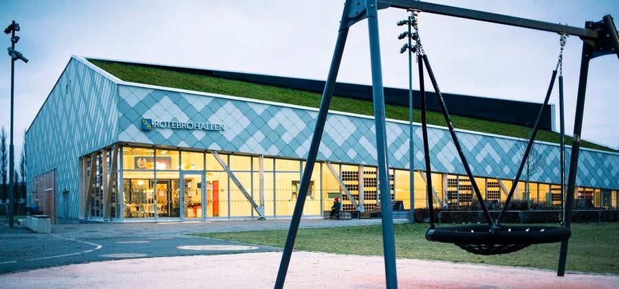 En byggnad som har en gungställning framför sig.