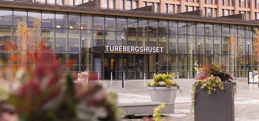 En stor byggnad med en skylt där det står Turebergshuset.