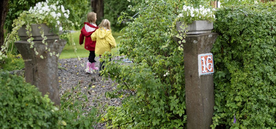 Entré med stolpe och två barn.