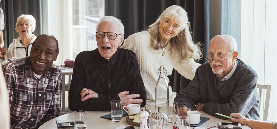 Male nurse photographing senior men and women at retirement home