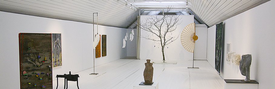 Ett rum fyllt med skulpturer och ett träd.