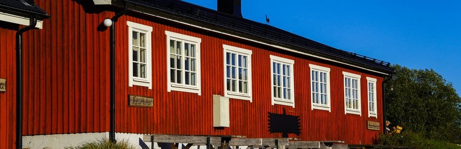 En röd byggnad med ett picknickbord framför.