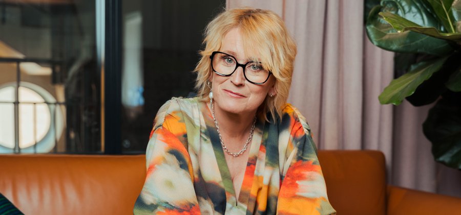 Promilletanten och föreläsaren Anna Sjöström sitter lätt framåtlutad  i en brun skinnsoffa med armarna mot knäna.