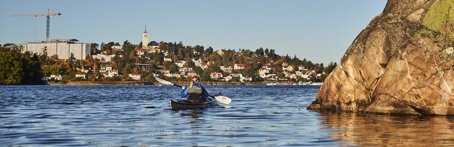 En person som paddlar kajak på Edsviken..